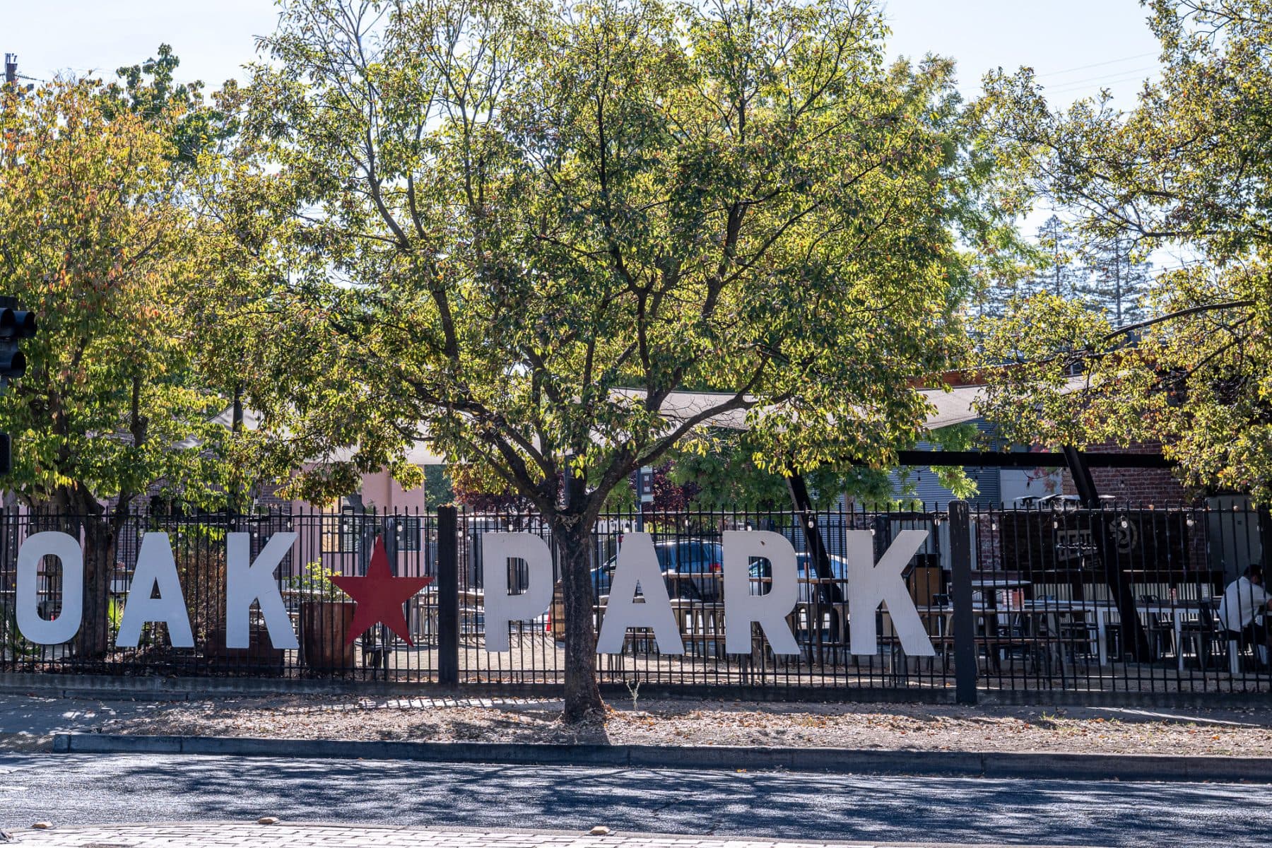 The OAK PARK letter sign on a fence along the street