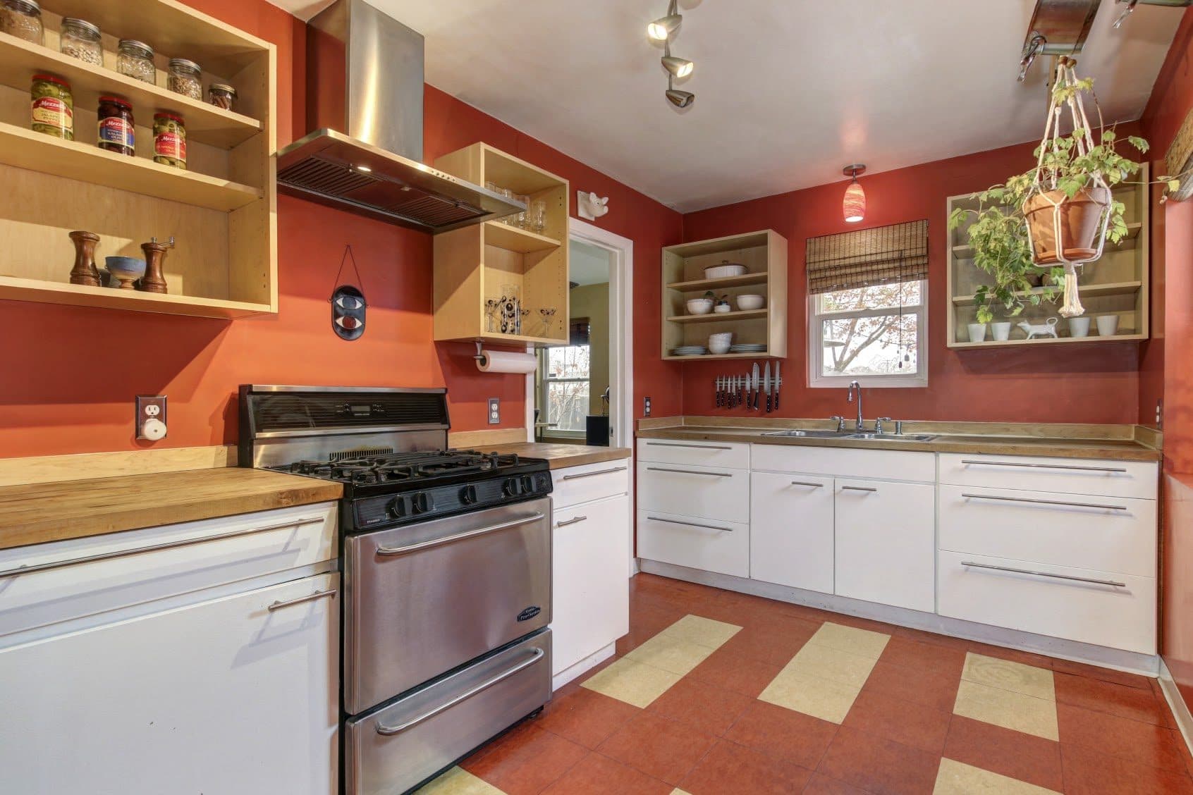 A warm terracotta kitchen with open shelving